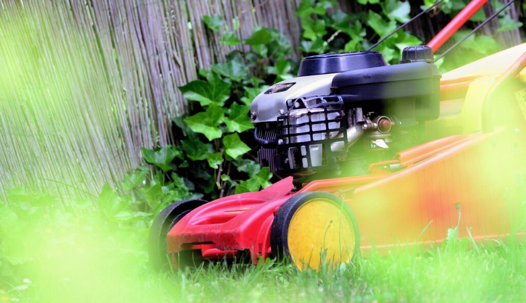 débroussailleuse dans un jardin sur de la pelouse verte